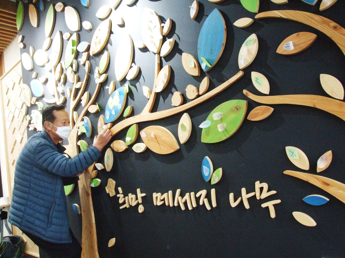 희망 메시지 나무를 살펴보는 박정서(74세) 씨