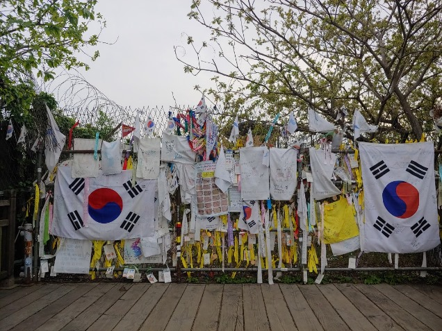자유의 다리에서 북쪽으로 가는 길을 막는 철조망에는 통일의 염원을 담은 국민들의 메시지와 리본이 달려있다